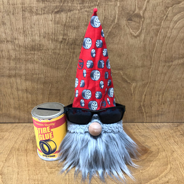 hand crafted gnome with a vintage can of tire glue that is a bank.